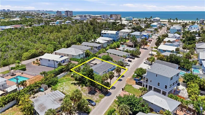 Coastal community setting featuring a single-story residence with mature palm trees - Virtually Edited Image