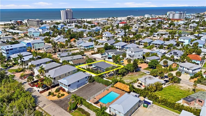 Coastal neighborhood with a visible body of water, dense residential homes, and mature landscaping
