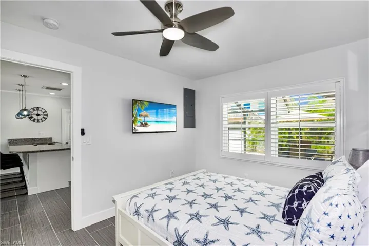 Bedroom with a ceiling fan and electric panel - Virtually Edited Image