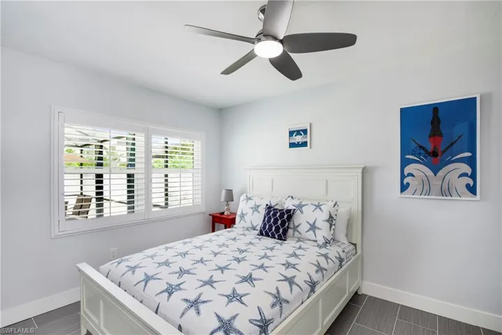Bedroom featuring a ceiling fan and wood tiled floors - Virtually Edited Image