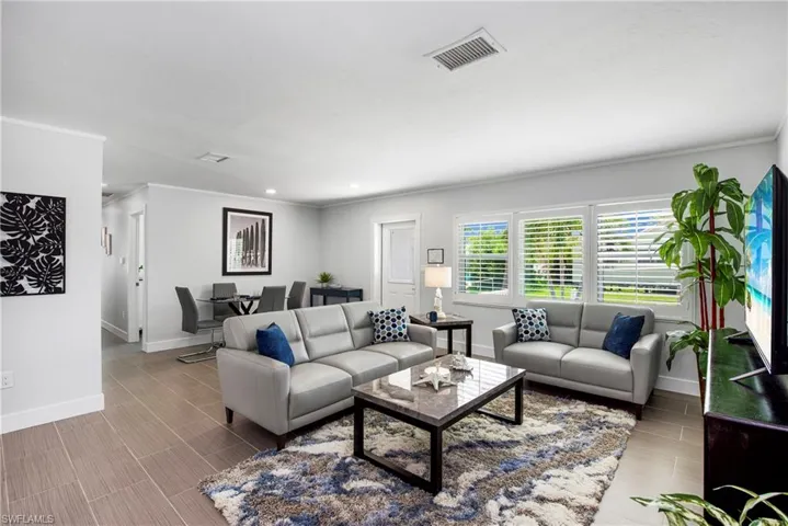 Living room with wood finish floors and crown molding - Virtually Edited Image