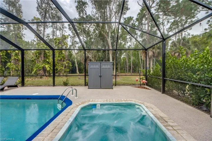 Outdoor pool with a lanai, a sunroom, and a hot tub