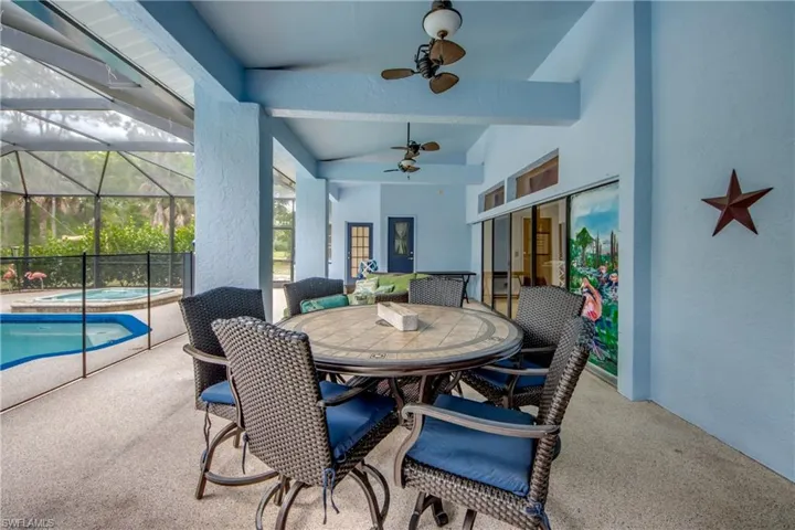 View of patio with an in-ground hot tub, a lanai, outdoor dining area, and a sunroom