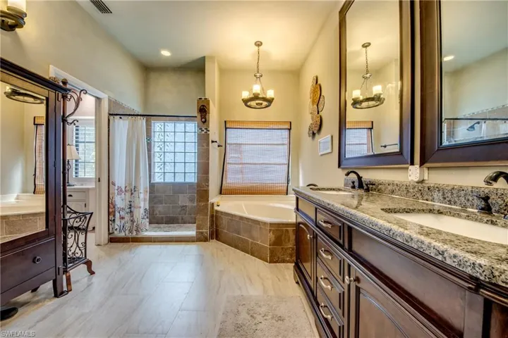 Bathroom featuring double vanity, a shower stall, a bath, and recessed lighting