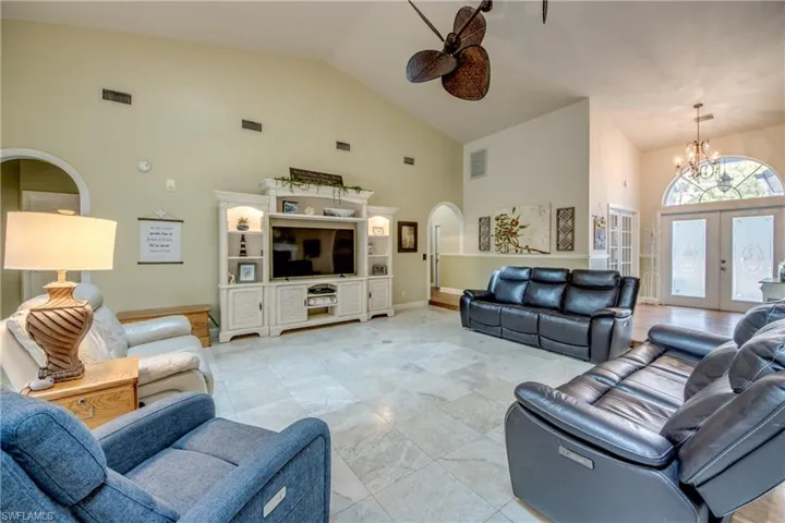 Living area with high vaulted ceiling, french doors, and arched walkways