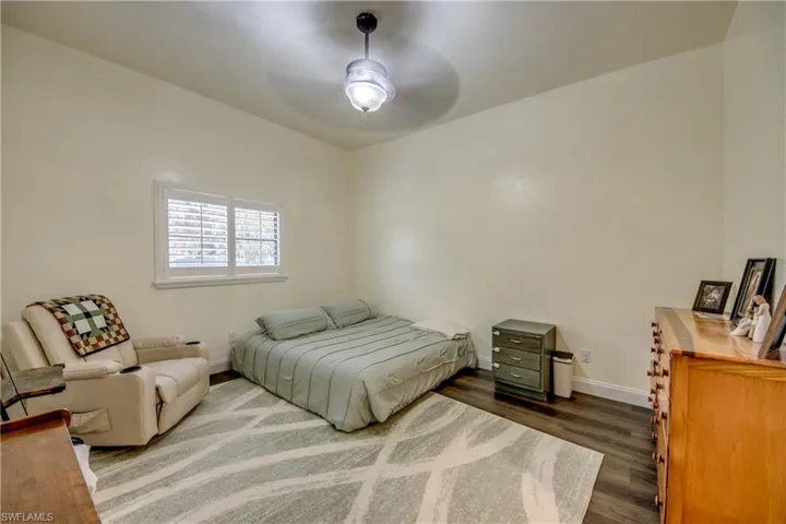 Bedroom with dark wood-style floors and ceiling fan