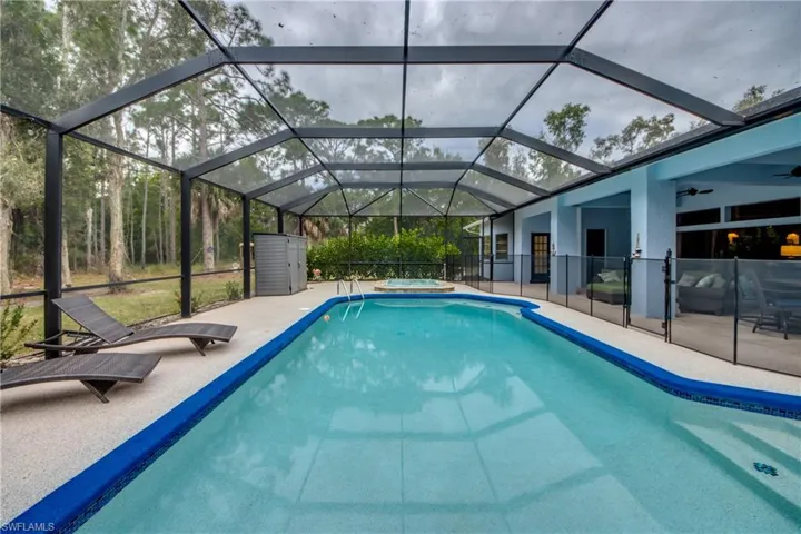 View of pool featuring an in-ground hot tub, a lanai, a sunroom, and a patio