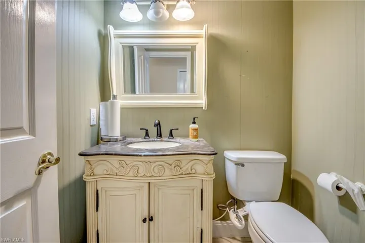 Half bathroom featuring vanity and wood walls