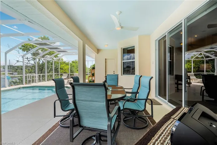 Sunroom / solarium with ceiling fan and a swimming pool