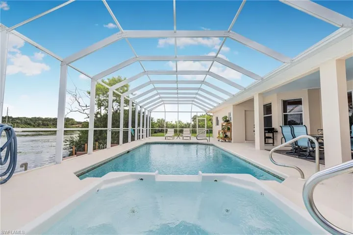View of swimming pool featuring glass enclosure and a patio area