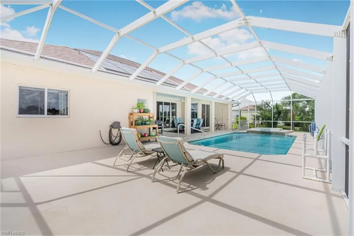 View of swimming pool featuring a patio, an in ground hot tub, and a lanai