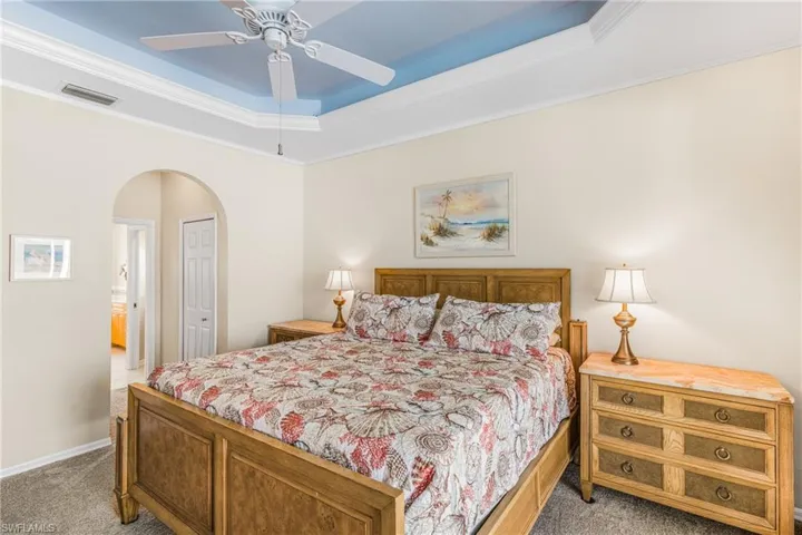 Bedroom with light carpet, a closet, ceiling fan, and crown molding