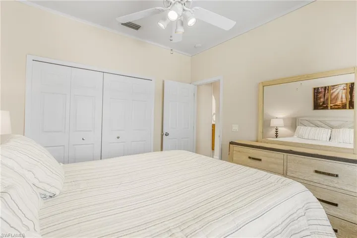 Bedroom with ornamental molding, a closet, and ceiling fan