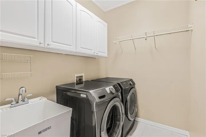 Washroom featuring cabinets, washing machine and dryer, and sink