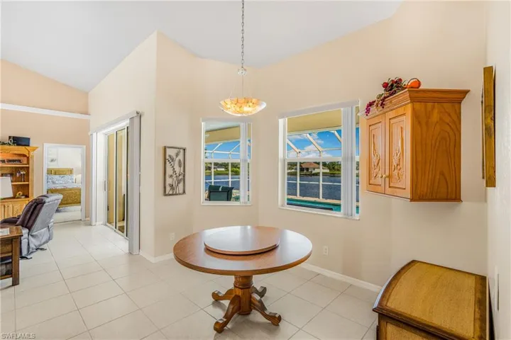Tiled dining room featuring lofted ceiling and a chandelier