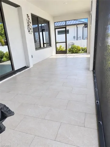 Screened patio featuring rectangular floor tiles and recessed lighting