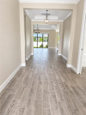 Wood-finish flooring throughout, recessed lighting, and tray ceilings with crown molding