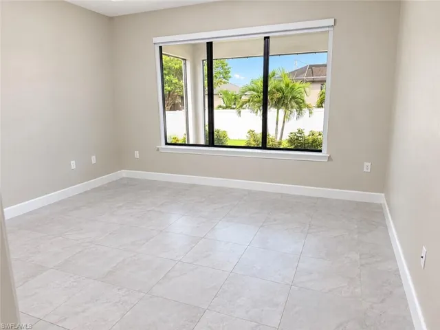 Expansive window providing abundant natural light, ceramic tile flooring, neutral wall tones, and white trim