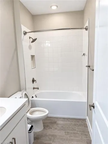 Bathtub and shower combination with white subway tile surround and integrated niche