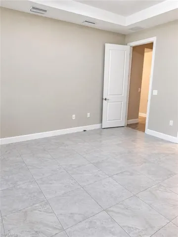 Tray ceiling, recessed lighting, tile flooring, two-panel interior door, neutral wall paint