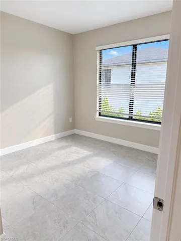 Tile flooring, neutral wall tones, large window, white trim