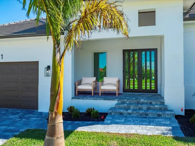 View of exterior entry with stucco siding, french doors, and an attached garage