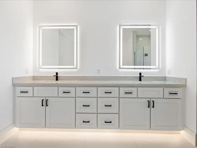 Bathroom featuring double vanity and light tile patterned flooring