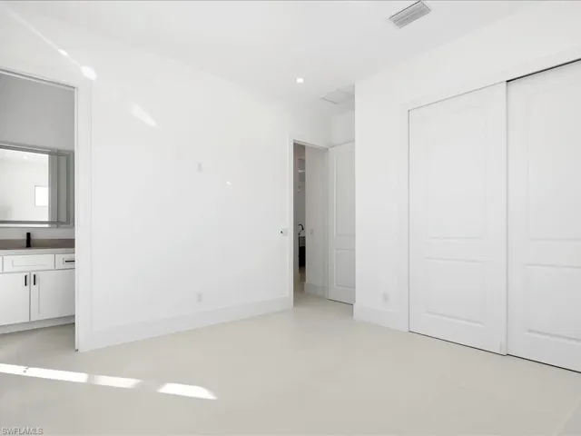 Unfurnished bedroom with ensuite bathroom, recessed lighting, and a closet