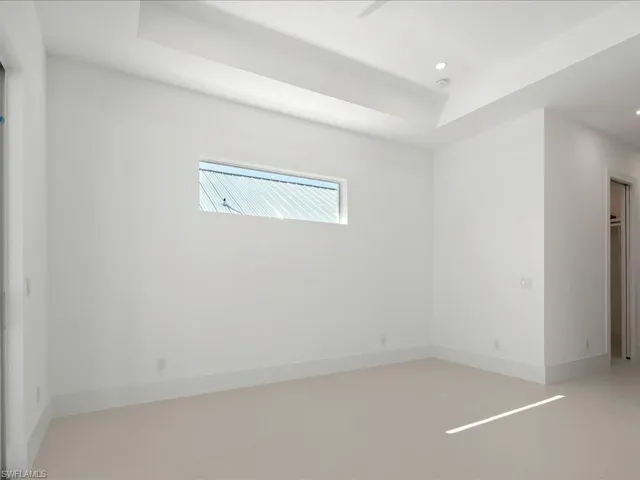 Unfurnished room featuring a tray ceiling and recessed lighting