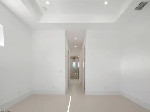 Unfurnished room with recessed lighting and a raised ceiling