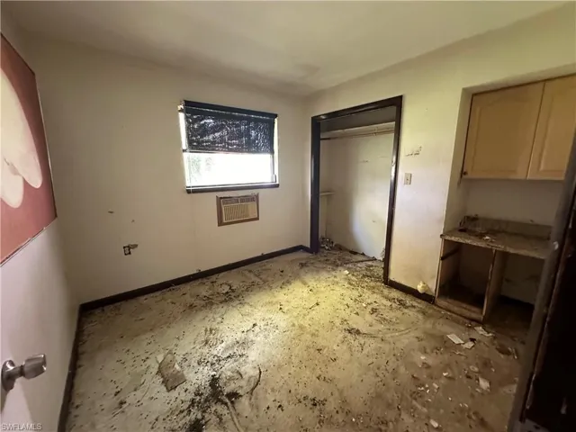 Unfurnished bedroom featuring a wall mounted AC and a closet