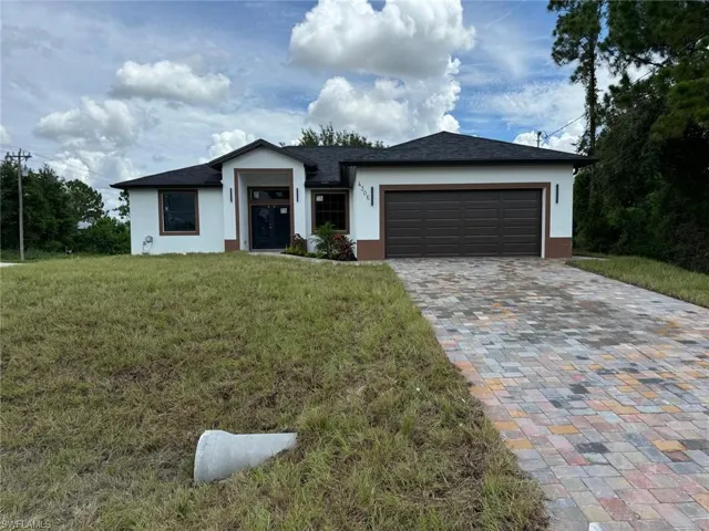 View of front of house with a garage and a front lawn