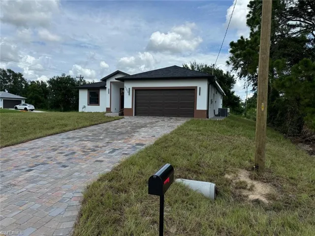 View of front of home featuring a garage and a front yard