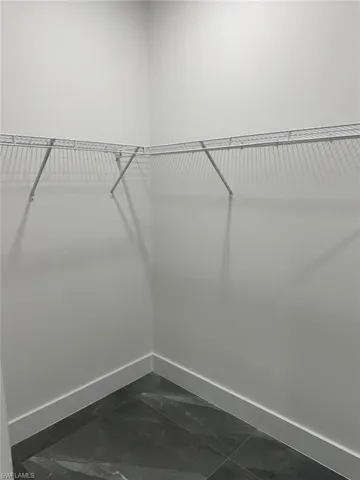 Walk in closet featuring dark tile flooring