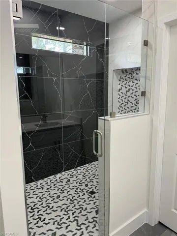 Bathroom with tile floors and a shower with shower door