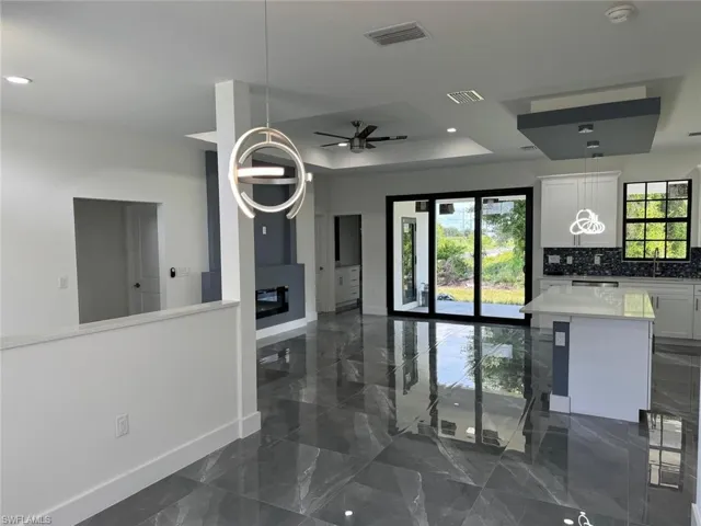 Kitchen featuring white cabinets, tasteful backsplash, dark tile flooring, and ceiling fan