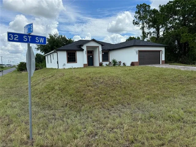 View of front of home featuring a garage and a front lawn