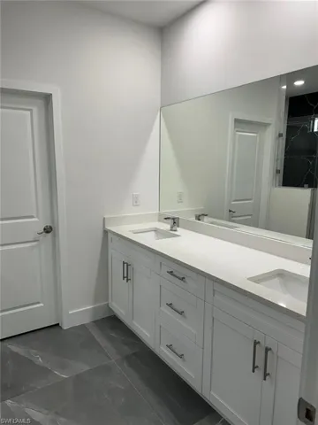 Bathroom with dual bowl vanity and tile flooring