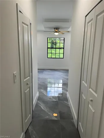 Hall featuring dark tile flooring