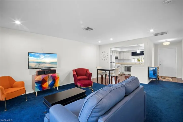 Carpeted living room with recessed lighting and baseboards
