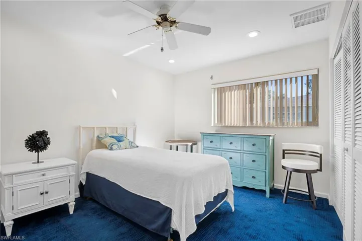 Bedroom with dark carpet, ceiling fan, a closet, and recessed lighting