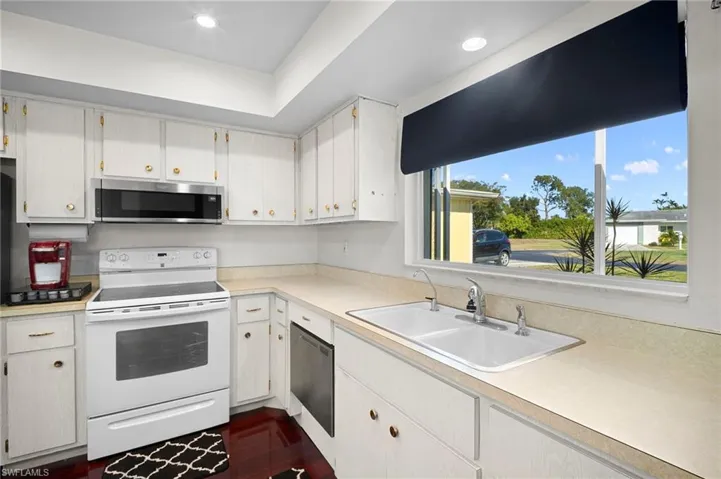 Kitchen featuring stainless steel appliances, light countertops, white cabinets, and recessed lighting