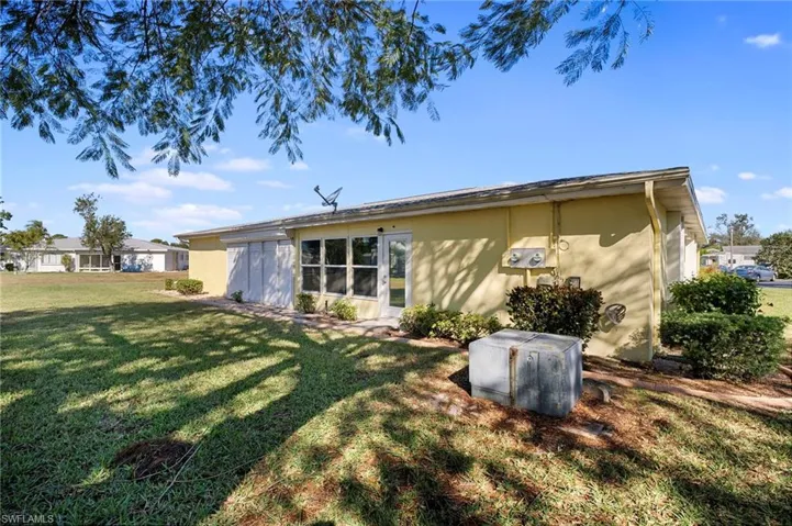Rear view of house with a yard and stucco siding