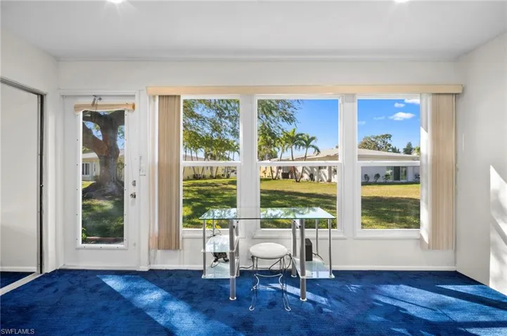 Doorway featuring carpet floors and baseboards