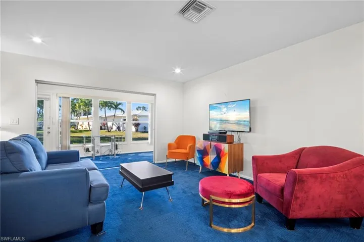 Carpeted living room with recessed lighting and baseboards