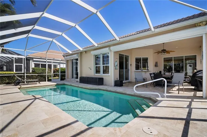Outdoor pool with a sunroom, a patio area, and a lanai