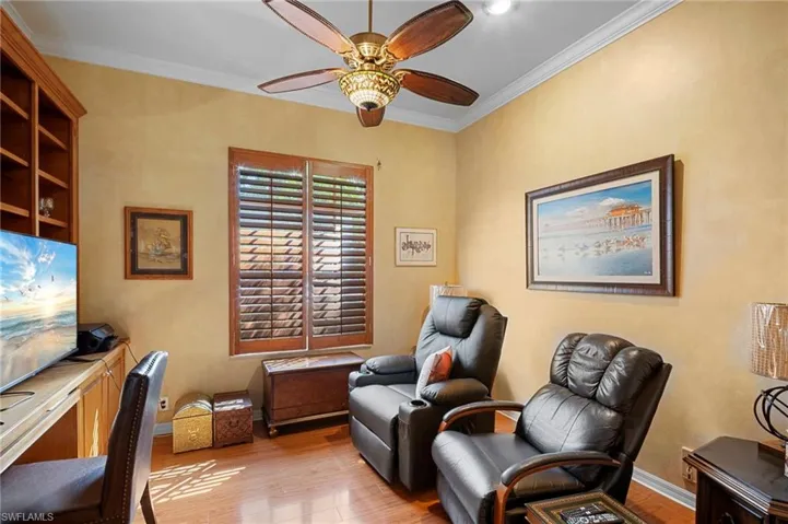 Office space featuring light wood-type flooring, crown molding, and ceiling fan