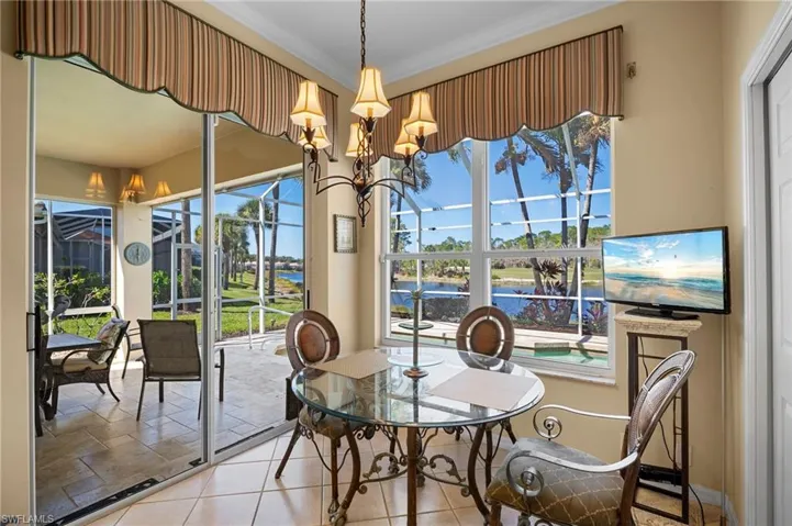 Dining area with a chandelier, tile patterned flooring, and ornamental molding