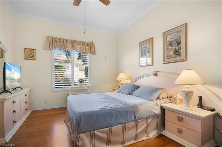 Bedroom featuring crown molding, wood finished floors, and ceiling fan