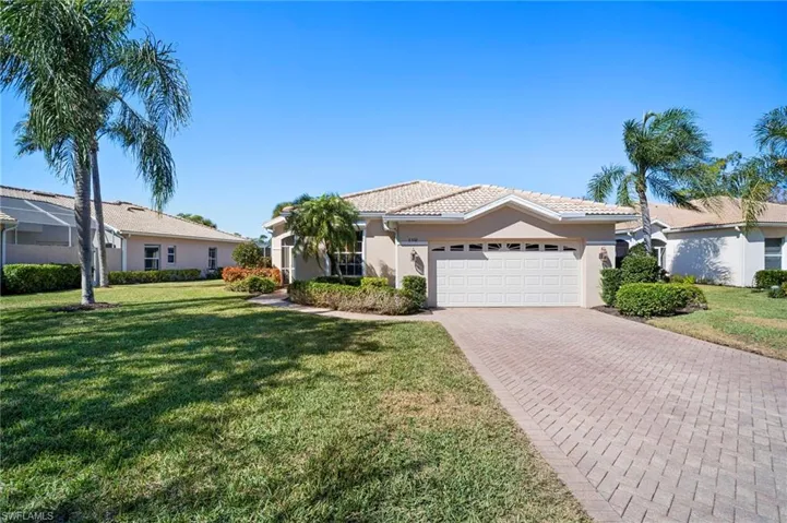 Single story home featuring a front lawn, stucco siding, decorative driveway, an attached garage, and a tile roof
